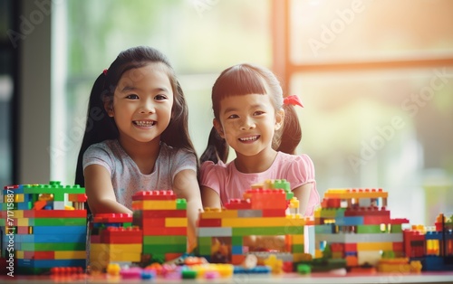 Two Young Girls Engaged in Creative Play With Colorful Building Blocks Indoors