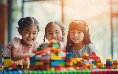 Three Young Children Engaged in Creative Play With Colorful Building Blocks Indoors