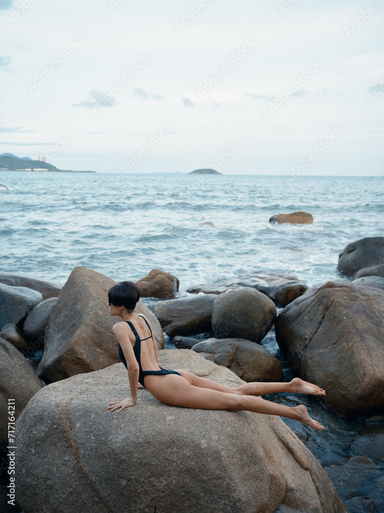 Exquisite Summer: A Sensual Swimwear Model Posing on a Rock, Surrounded by Sand and Crystal-clear Ocean Waters Exquisite Summer: A Sensual Swimwear Model Posing on a Rock, Surrounded by Sand and Crystal-clear Ocean Waters