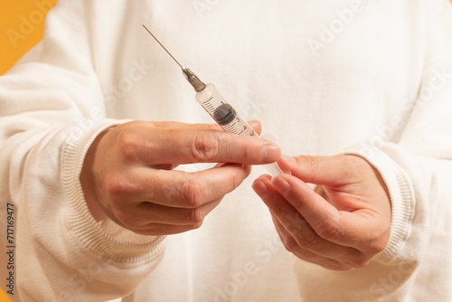 Hand holding a syringe, needle pointing up