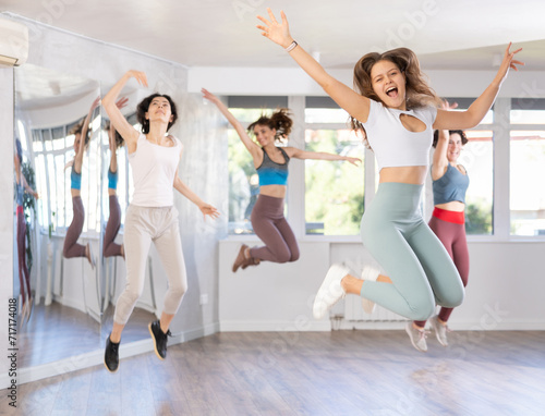 Portrait of satisfied girls jumping having fun after dance class