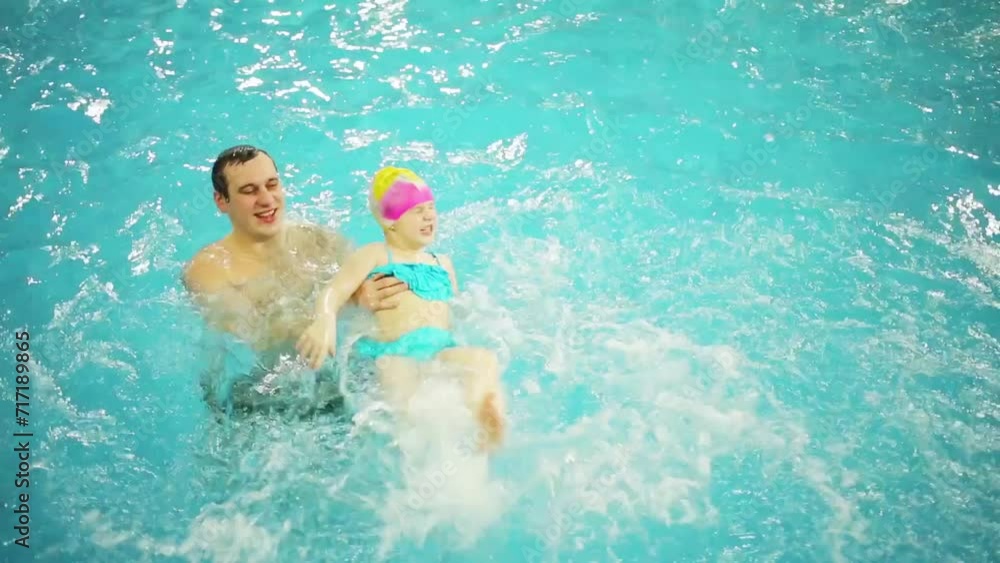 Father teaches little daughter to swim in pure pool Father teaches little daughter to swim in pure pool