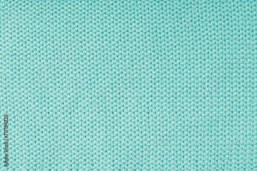 Close up background of knitted wool fabric made of viscose yarn, turquoise color wool knitwear texture. Sweater, pullover knitted jersey background. Fabric abstract backdrop, wallpaper
