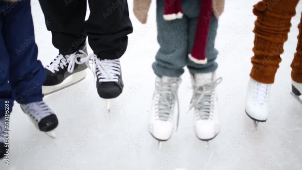 Legs of father with daughter and two happy cute kids skating Legs of father with daughter and two happy cute kids skating