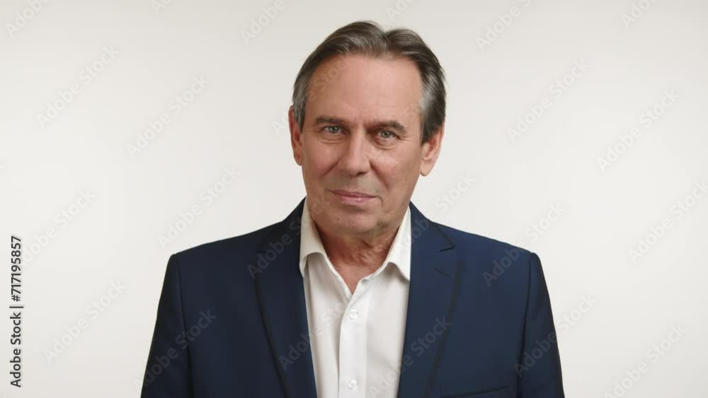 A mature man in a suit gives a head shake indicating 'no,' his demeanor showing disagreement or disapproval, with a subtle look of decision against a white background. Camera 8K RAW. A mature man in a suit gives a head shake indicating 'no,' his demeanor showing disagreement or disapproval, with a subtle look of decision against a white background. Camera 8K RAW.