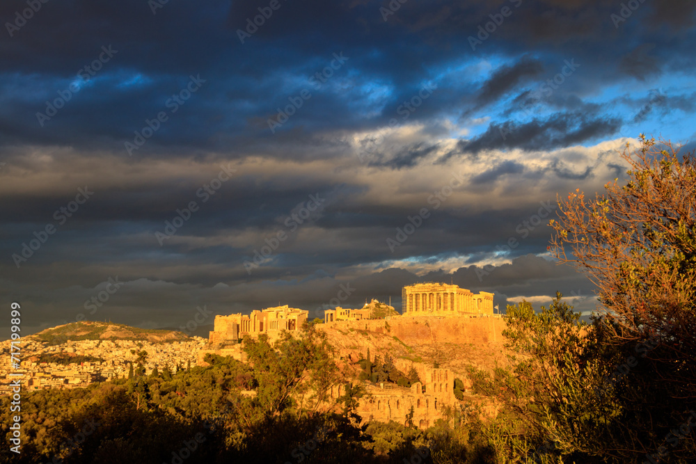 View of the Acropolis Hill, crowned with Parthenon during evening golden hour from the Philopappos Hill in Athens, Greece