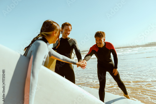 Φωτογραφία Group of surfers greet each other by shaking hands before surfing on waves in oc
