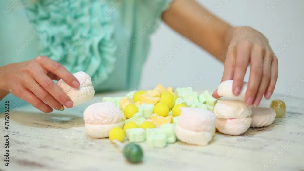 Hands of girl touching many yellow and white sweets on table Hands of girl touching many yellow and white sweets on table