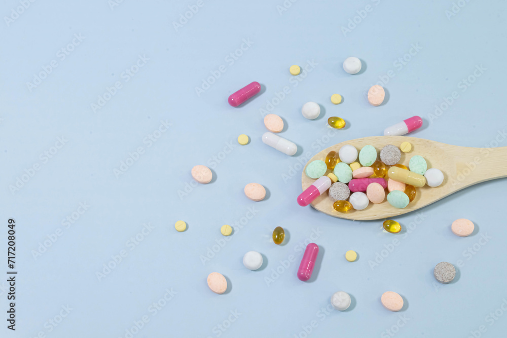 Assorted pharmaceutical medicine pills, tablets and capsules on wooden spoon. Assorted pharmaceutical medicine pills, tablets and capsules on wooden spoon.