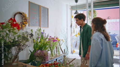 Multiethnic couple enjoy florist store together. Two lovers shop flowers plant. photo
