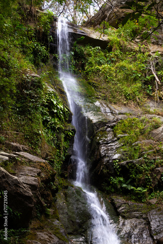 Fototapeta Naklejka Na Ścianę i Meble -  waterfall flowing through rock surrounded by green moss walls
