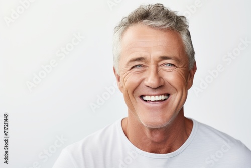 Portrait of handsome mature man with grey hair smiling and looking at camera