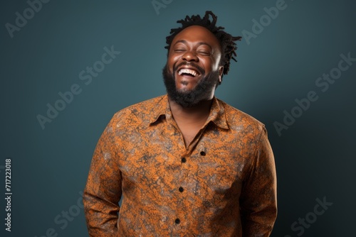 Portrait of a happy african american man laughing over dark background