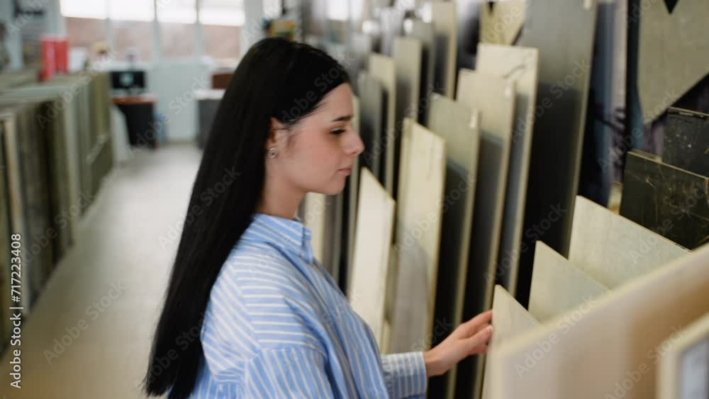 A woman chooses ceramic tiles in a hardware store A woman chooses ceramic tiles in a hardware store
