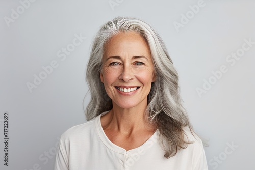 happy senior woman with grey hair and white t-shirt over grey background