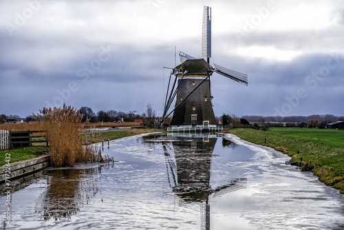 Winter landscape with traditional Dutch windmill in Leidschendam, near The Hague, Netherlands, Holland, Europe photo