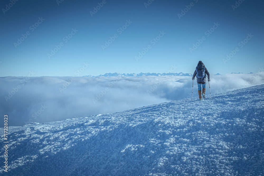 Turysta nad chmurami schodzący z Babiej góry, widok na Tatry