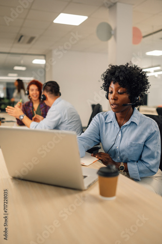 African american female agent wearing headset and resolving problems remotely