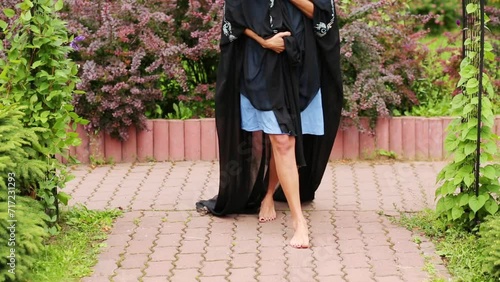 Legs of woman in black sari walking in tile in park  photo