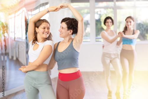 Woman paired girl and dancing vigorous boggie-woogie in couple during group lesson at studio. Leisure activities and physical activity for positive people. © JackF