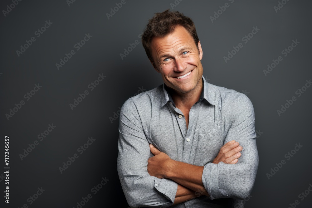 Portrait of a handsome smiling man standing with arms crossed against grey background. Portrait of a handsome smiling man standing with arms crossed against grey background.