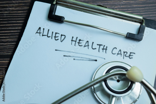 Concept of Allied Healthcare write on paperwork with stethoscope isolated on wooden background.