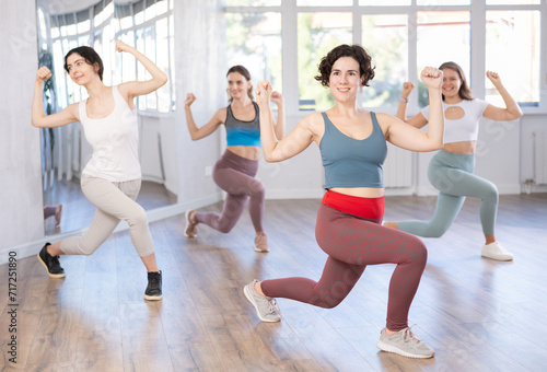 Female coach conducts classes in modern energetic dancing for young girls. Concept of active hobby, pleasant way to lose weight and maintain perfect figure
