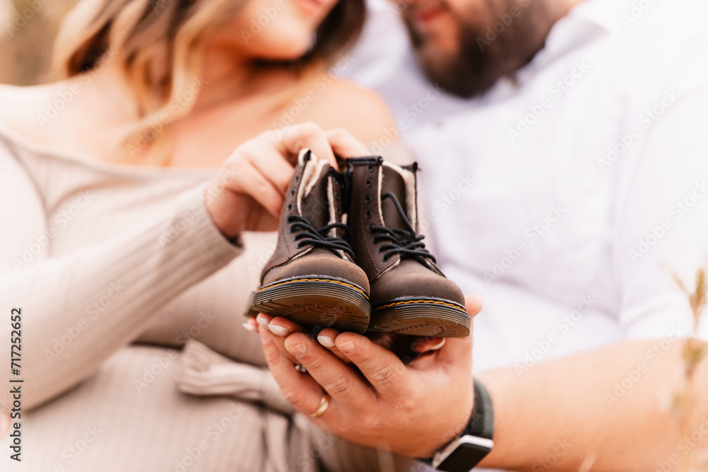 Fototapeta premium Couple is holding little baby boots