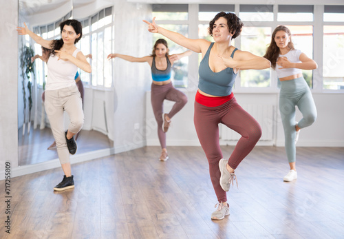 Cheerful women practicing contemporary dances in dance studio