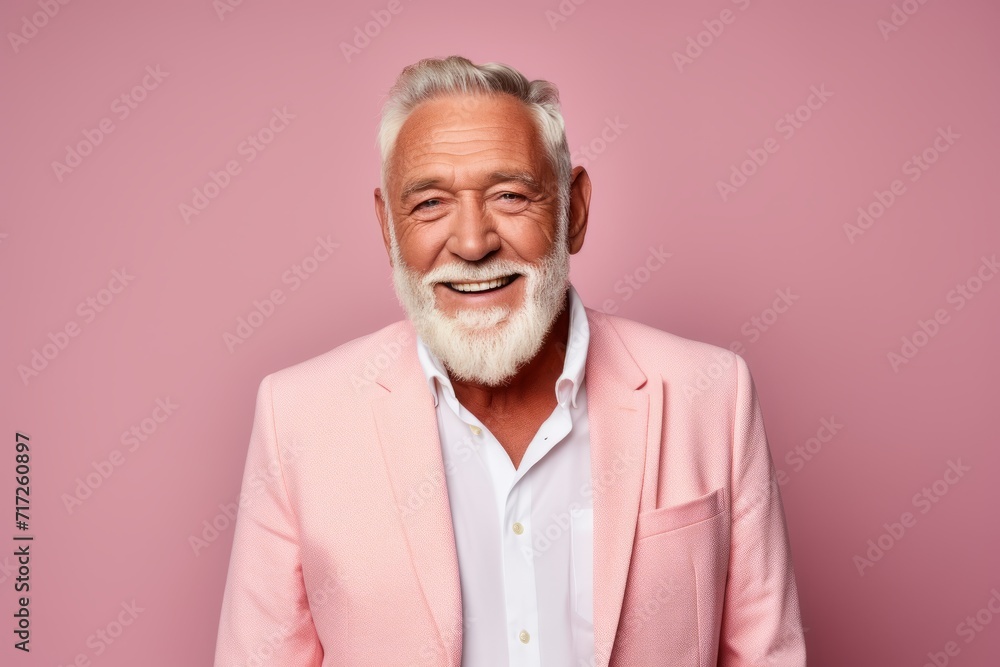 Portrait of a smiling senior man in a pink suit on a pink background. Portrait of a smiling senior man in a pink suit on a pink background.
