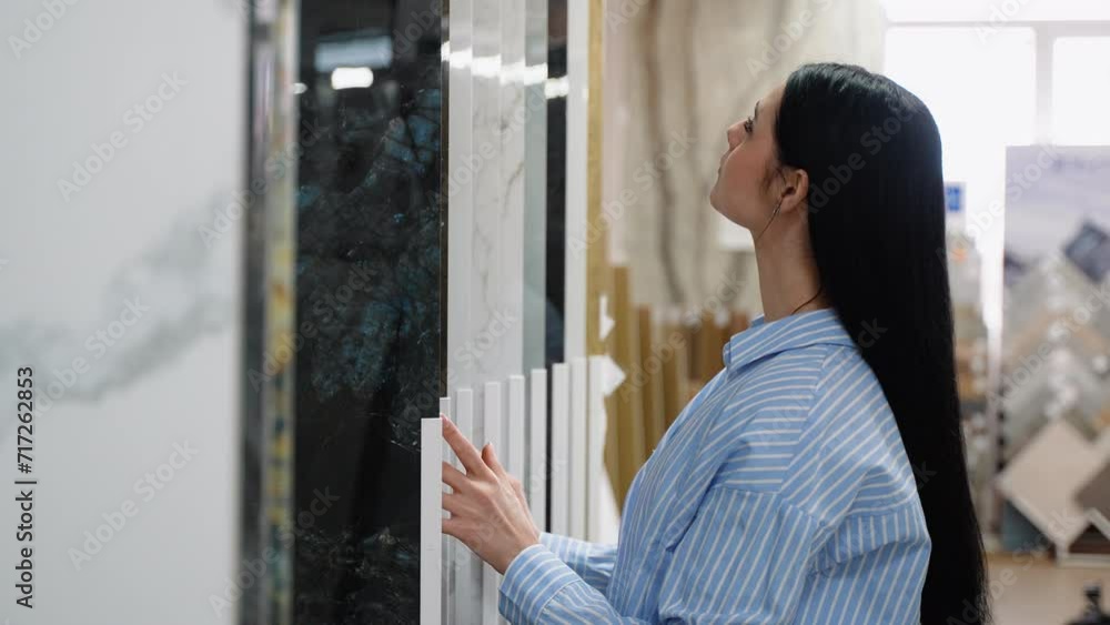 A woman chooses ceramic tiles in a hardware store A woman chooses ceramic tiles in a hardware store
