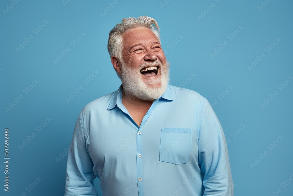 Portrait of happy senior man laughing and laughing against blue background. Portrait of happy senior man laughing and laughing against blue background.
