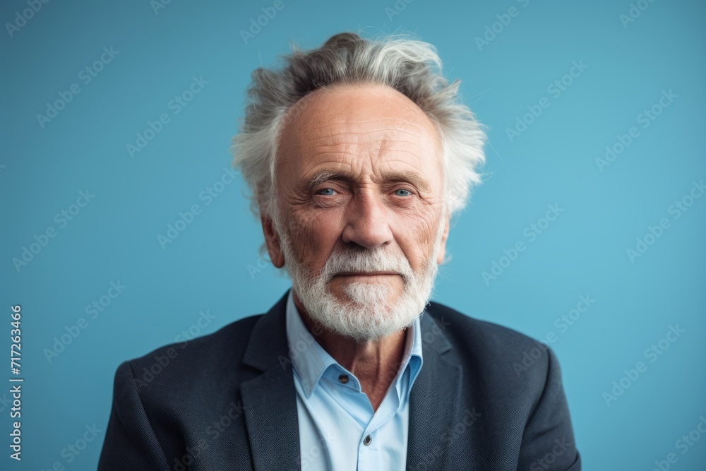 Portrait of a senior man with grey hair and beard. Isolated on blue background. Portrait of a senior man with grey hair and beard. Isolated on blue background.