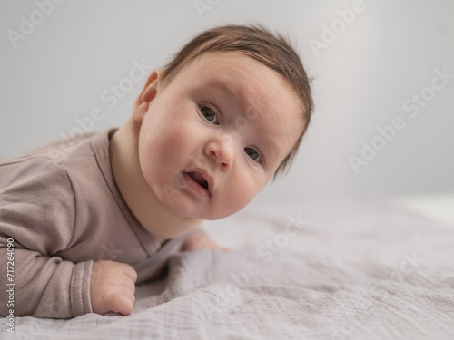 Portrait of a newborn baby lying on his stomach in an orthopedic collar. photo