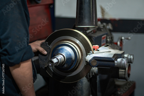 Mechanic grinding car brakes in workshop