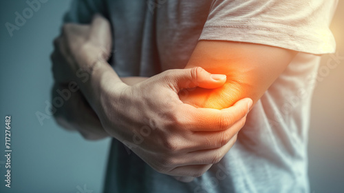 Close-up of a person clutching their elbow in pain, highlighting muscle discomfort, health concerns, joint inflammation, and chronic pain management. photo
