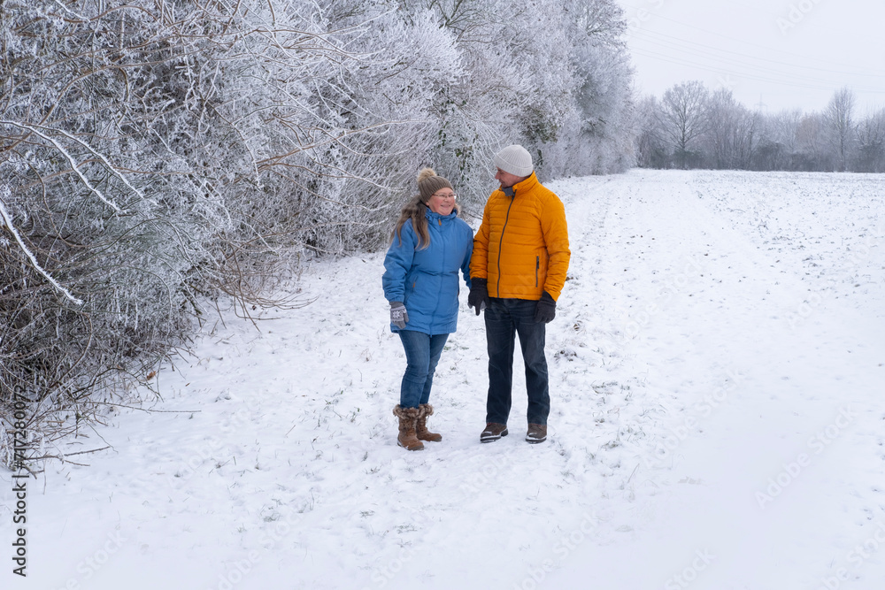 Winter wonderland scene with joyful mature couple enjoying leisurely stroll through picturesque park, surrounded serene snow-covered landscapes, Winter Romance, Nature Walks