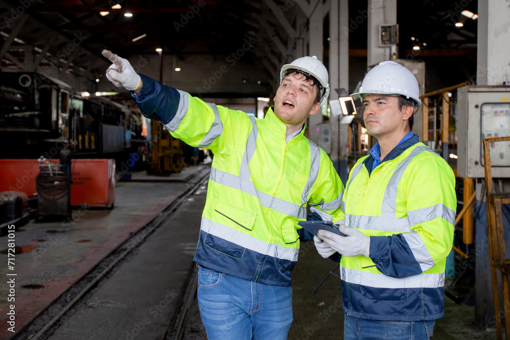 Team caucasian engineer checking train looking tablet in station, team engineer inspect system transport, technician examining infrastructure and talking with partner, transportation and industry. Team caucasian engineer checking train looking tablet in station, team engineer inspect system transport, technician examining infrastructure and talking with partner, transportation and industry.