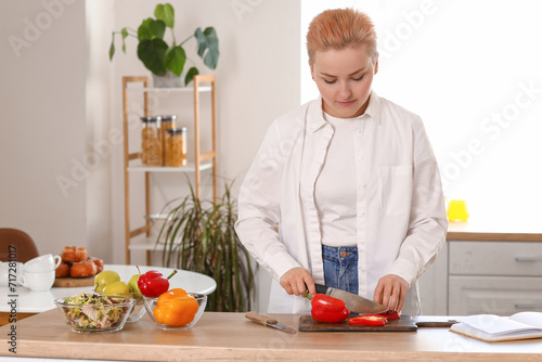 Young woman cutting bell pe...