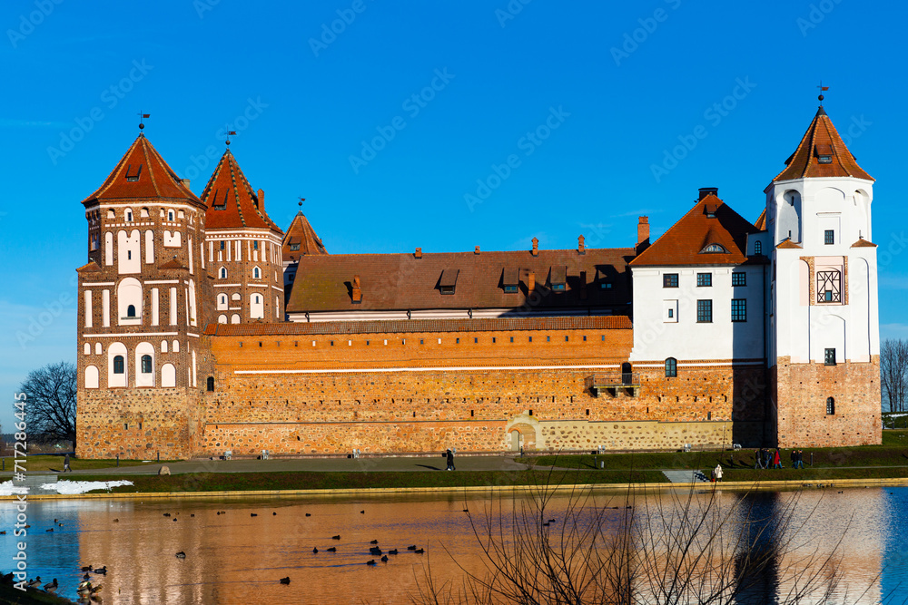 View of impressive medieval Castle surrounded by ponds in Belarusian town of Mir on winter day
