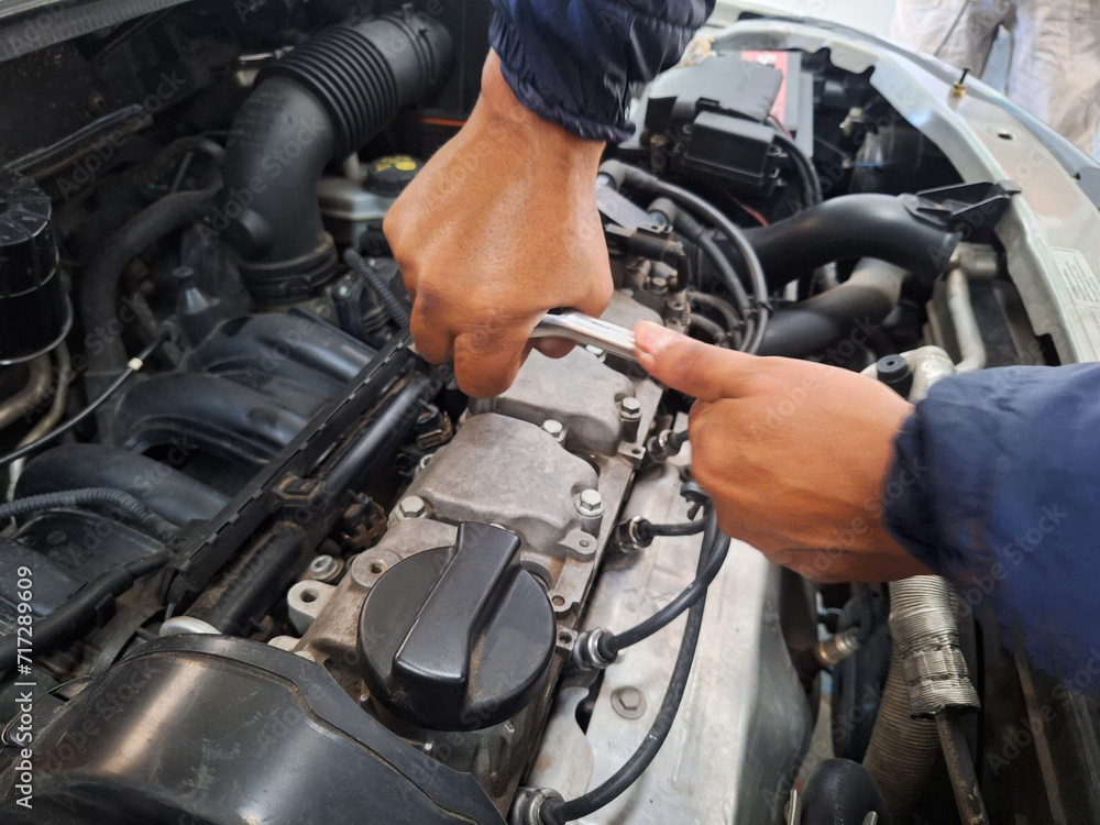 a man closing the engine of a car a man closing the engine of a car
