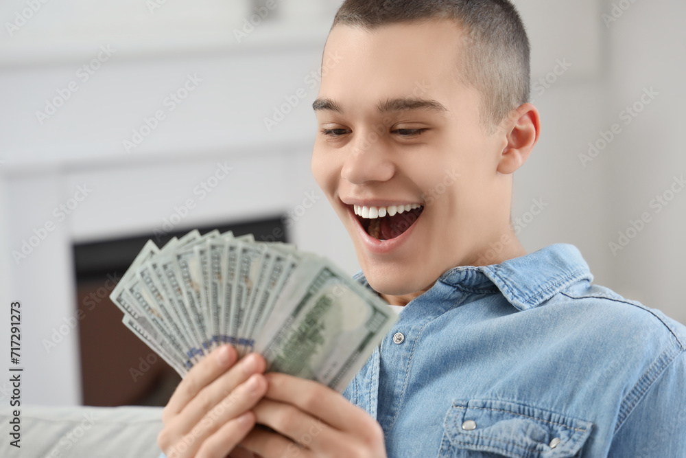 Happy young man with dollar banknotes at home, closeup Happy young man with dollar banknotes at home, closeup
