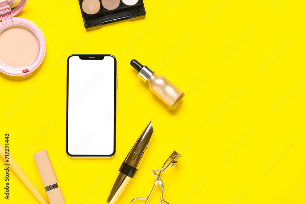 Naklejka premium Composition with modern mobile phone, cosmetics and makeup accessories on yellow background