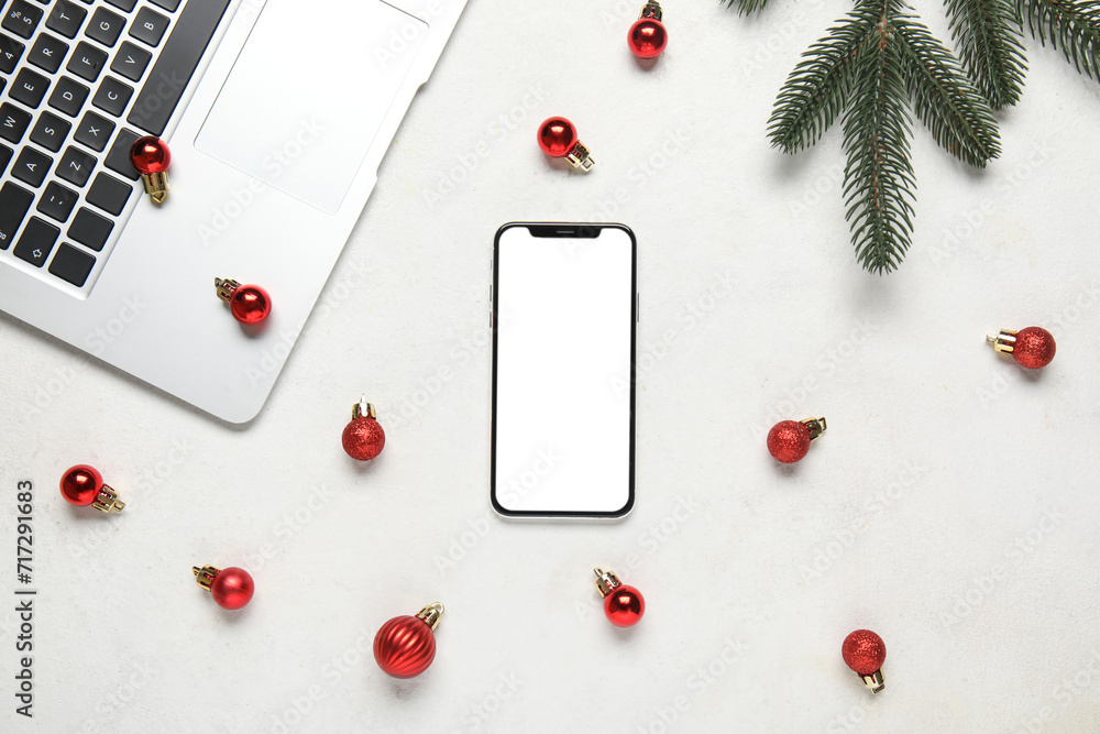 Composition with modern mobile phone, laptop and Christmas balls on light background Composition with modern mobile phone, laptop and Christmas balls on light background