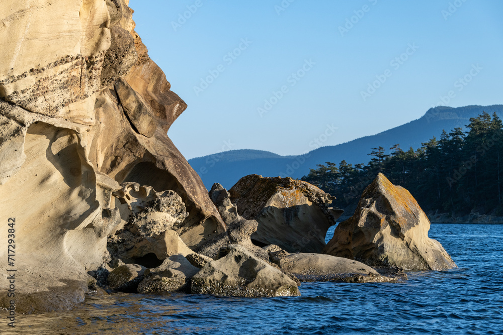 Sucia Island Marine State Park - rock formations along the shoreline with mountains in the background