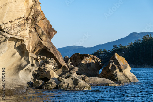 Sucia Island Marine State Park - rock formations along the shoreline with mountains in the background