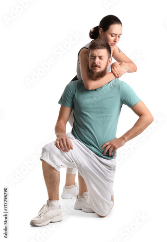 Εκτύπωση καμβά Young woman fighting with instructor of self-defence course on white background