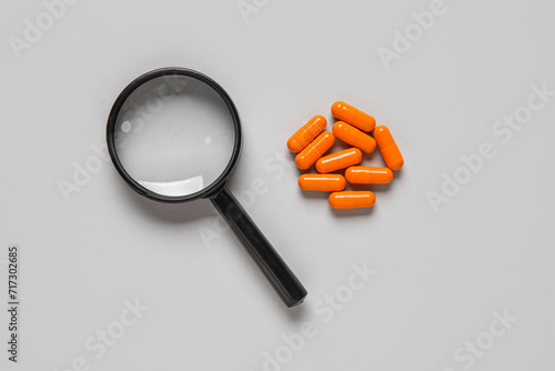 Magnifier with pills on gre...
