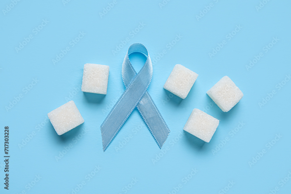 Awareness ribbon with sugar cubes on blue background. Diabetes concept Awareness ribbon with sugar cubes on blue background. Diabetes concept