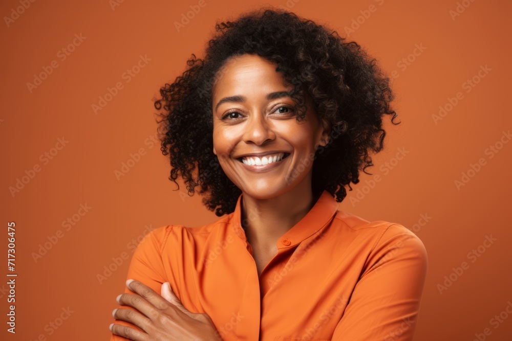 Portrait of smiling african american woman in orange shirt on orange background Portrait of smiling african american woman in orange shirt on orange background